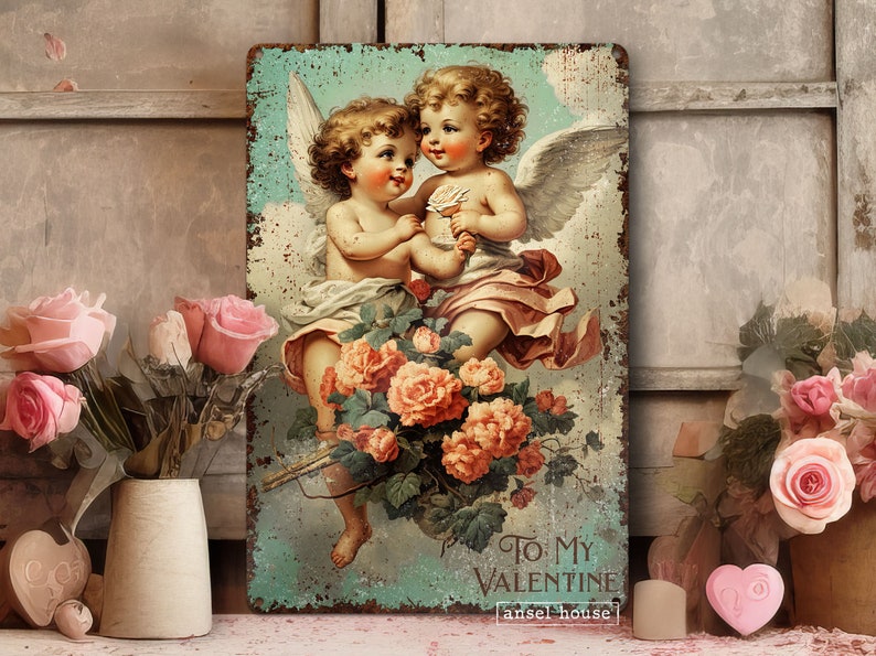 May include: Vintage-style metal sign featuring two cherub angels with wings, holding roses and a banner that reads "To My Valentine" with the text "[ansel house]" below. The sign has a distressed, aged look and is surrounded by a floral border.