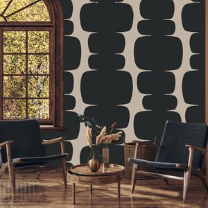 Peut inclure: Deux chaises avec un rev&ecirc;tement bleu fonc&eacute; et des cadres en bois sont plac&eacute;es devant un mur avec un papier peint &agrave; motifs g&eacute;om&eacute;triques. Le papier peint pr&eacute;sente un motif r&eacute;p&eacute;titif de rectangles arrondis noirs sur un fond beige clair.