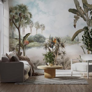 May include: A living room interior design with a tropical mural featuring palm trees, banana plants, and a river. The mural is painted in watercolor style with muted green, blue, and brown tones. A gray sofa and a white armchair are placed in front of the mural, with a wooden coffee table in between.