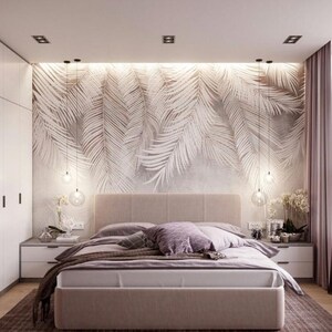 May include: A bedroom with a white bed, white nightstands, and a white closet. The wall behind the bed has a white and gray palm leaf wallpaper. There are three pendant lights hanging from the ceiling.