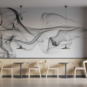 May include: Interior of a cafe with a large wall mural depicting a black and grey abstract smoke design. The space features round tables, light wood chairs, and pendant lights, creating a minimalist aesthetic.