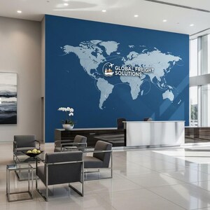 Pu&ograve; includere: Una hall d'ufficio con una grande parete blu con una grafica della mappa del mondo e il testo "GLOBAL FREIGHT SOLUTIONS". La hall comprende poltrone grigie, tavoli in vetro e un banco reception bianco. Il pavimento &egrave; in piastrelle bianche.