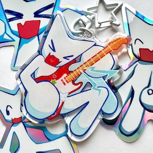Puede incluir: Varios llaveros de acrílico transparente con un personaje de dibujos animados blanco tocando una guitarra eléctrica roja y naranja. El personaje tiene una boca roja y un diseño en forma de estrella en la guitarra. Los llaveros tienen un cierre plateado.