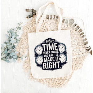 May include: A white canvas tote bag with cream-colored handles. The bag features a navy blue and white graphic with the text "THE RIGHT TIME NEVER COMES, YOU HAVE TO MAKE IT RIGHT." Four clock faces are also included in the design.