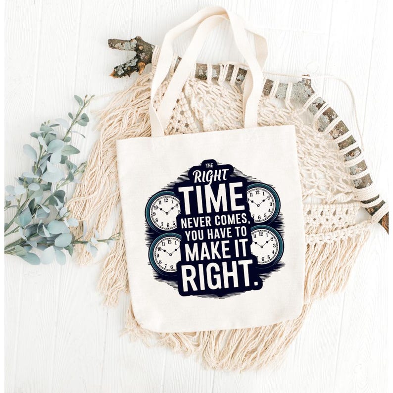May include: A white canvas tote bag with cream-colored handles. The bag features a navy blue and white graphic with the text "THE RIGHT TIME NEVER COMES, YOU HAVE TO MAKE IT RIGHT." Four clock faces are also included in the design.