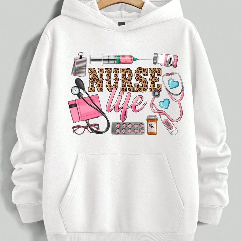 May include: White hoodie with a graphic design featuring medical tools and the text "NURSE life" in a leopard print font. The design includes a stethoscope, syringe, pills, and a thermometer.