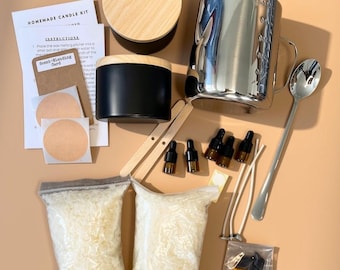 May include: A homemade candle kit containing a stainless steel pouring pitcher, a black candle tin with a wooden lid, two bags of white wax flakes, wooden stir sticks, a metal spoon, four small amber dropper bottles, candle wicks, and instruction cards.