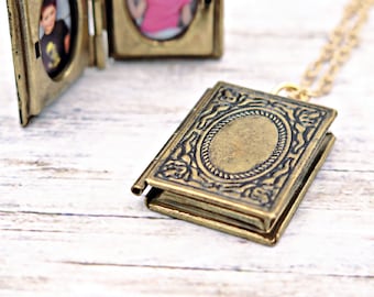 May include: A gold-toned locket necklace with an ornate design. The locket is open, revealing a blank space inside.
