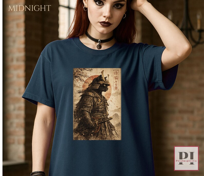 May include: Navy blue t-shirt featuring a detailed illustration of a samurai cat with a red sun in the background. The shirt has the word "MIDNIGHT" printed at the top left corner. The design is in a vintage style.