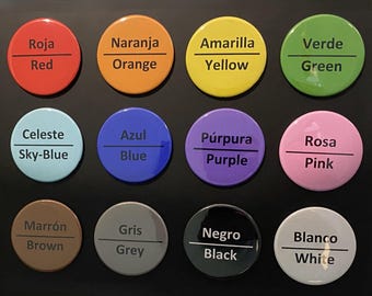 May include: A collection of twelve colorful round buttons, each displaying a different color name in both Spanish and English. Colors include red, orange, yellow, green, sky-blue, blue, purple, pink, brown, grey, black, and white.