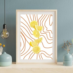 May include: A framed art print showing sliced lemons against a white background with orange wavy lines. The lemons are yellow and arranged vertically. The frame is a light wood colour. The print is suitable for a kitchen.