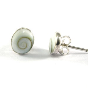 May include: A pair of silver stud earrings with a white shell design. The shell has a swirling pattern in shades of green and white.