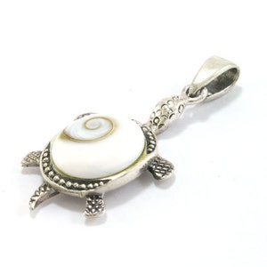 May include: Silver turtle pendant featuring a white and brown shell. The shell has a spiral pattern.