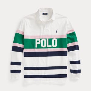 May include: A white long-sleeve rugby shirt featuring a collar and a button placket. The chest displays the word POLO in white letters over a wide green horizontal stripe. Additional horizontal stripes in pink and navy blue accent the body and sleeves.