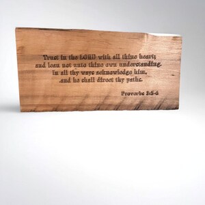 May include: A rectangular wooden plaque with engraved text. The text reads "Trust in the LORD with all thine heart; and lean not unto thine own understanding. In all thy ways acknowledge him, and he shall direct thy paths." Proverbs 3:5-6.