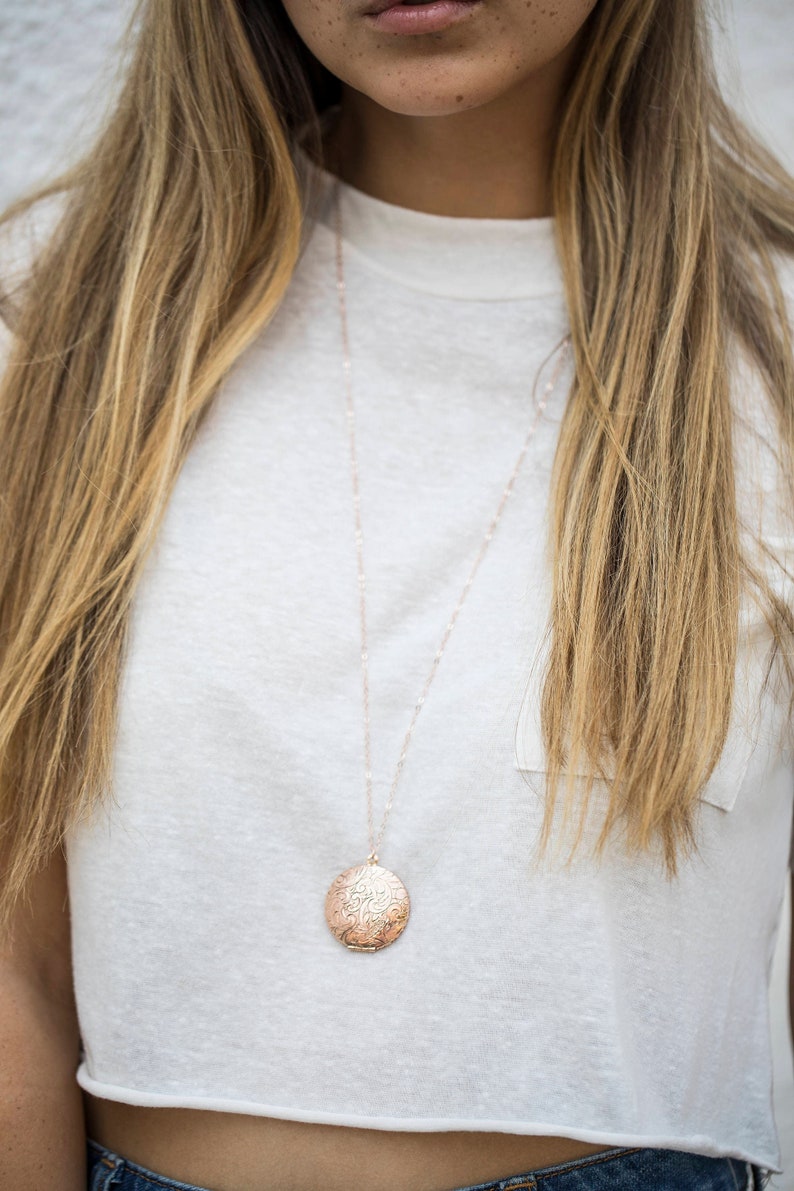 Op de afbeelding: Een ketting van ros&eacute;goud met een ronde, versierde hanger.