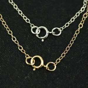 May include: Two necklaces with different clasps. The top necklace has a silver clasp and the bottom necklace has a gold clasp.