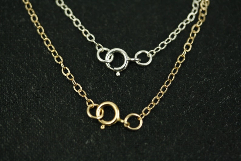May include: Two necklaces with different clasps. The top necklace has a silver clasp and the bottom necklace has a gold clasp.