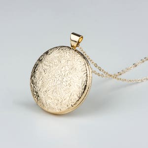 Shiny, medium sized gold photo locket with picture frames and small etched flower pattern.  14kt gold filled chain, long, medium or short length