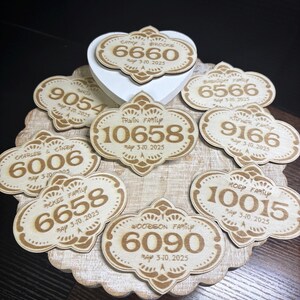 May include: A collection of eight wooden plaques with engraved numbers and text. Each plaque features a decorative border and the text "May 3-10, 2025".