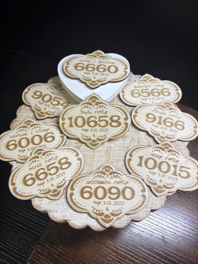 May include: A collection of eight wooden plaques with engraved numbers and text. Each plaque features a decorative border and the text "May 3-10, 2025".