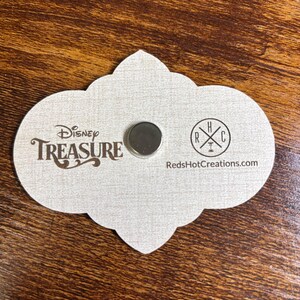 May include: A white card with a cloud-shaped outline. The card has the text "Disney TREASURE" in brown lettering and a small silver magnet. The bottom right corner of the card has the text "RedHotCreations.com" and a logo with the letters "RHC" in a circle.