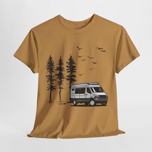 May include: A mustard yellow t-shirt with a graphic of a white camper van driving through a forest with black trees and birds flying overhead.