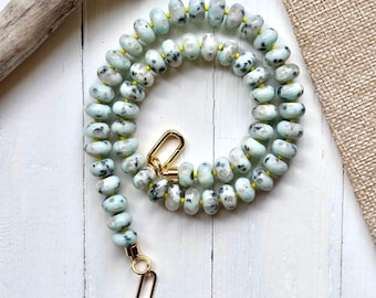 Collar con gema azul, jaspe kiwi, detalles en amarillo y baño de oro.