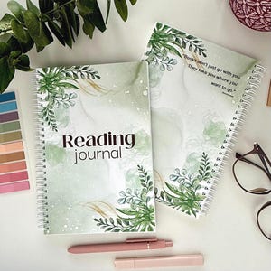 May include: Two spiral-bound reading journals with green and gold watercolor designs and botanical accents. One journal displays the text "Reading journal." The other journal has the quote, "Books don't just go with you. They take you where you want to go."