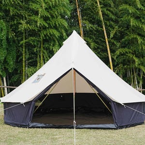 May include: A large, white canvas tent with a dark blue base and trim, set up on a grassy area. The tent has a central pole and is open at the front, revealing a dark interior. Bamboo trees are in the background.