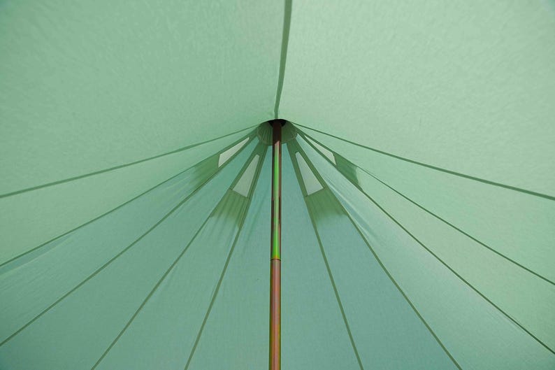 May include: A light green tent interior with a central brown pole. The tent's fabric radiates outwards from the top, creating a starburst pattern. The design includes reinforced sections and seams.