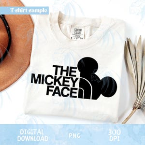 Op de afbeelding: Crèmekleurig T-shirt met de zwarte tekst "THE MICKEY FACE" en een zwart silhouet van Mickey Mouses hoofd. Het shirt heeft een Comfort Colors label. De woorden "DIGITAL DOWNLOAD", "PNG" en "300 DPI" zijn ook zichtbaar.