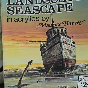 May include: A softcover instructional art book titled Technique and Textures Landscape Seascape in Acrylics by Maurice Harvey. The cover features a painting of a weathered wooden boat on a beach at sunset, with a large anchor in the foreground.