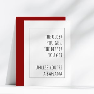 Op de afbeelding: Een witte wenskaart met een rode rand. De kaart bevat zwarte tekst die luidt: "HOE OUDER JE WORDT, HOE BETER JE WORDT. TENZIJ JE EEN BANAAN BENT."