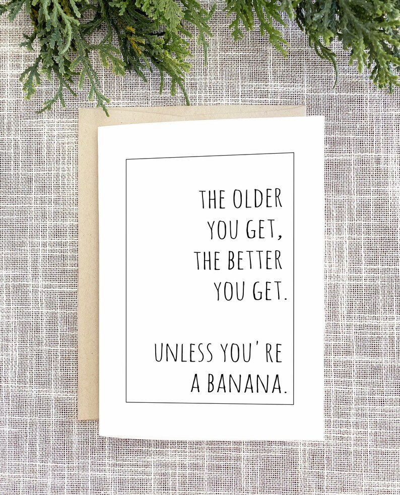Op de afbeelding: Een witte wenskaart met een zwarte rand en de tekst: "THE OLDER YOU GET, THE BETTER YOU GET. UNLESS YOU'RE A BANANA." De kaart zit in een bruine envelop, met groen op de achtergrond.