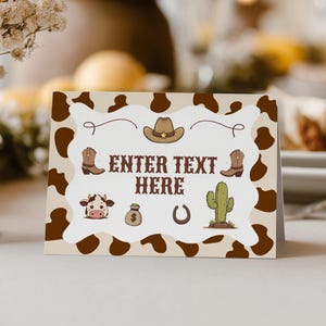 May include: A folded card with a cowboy theme. The card features a cowhide pattern and illustrations of a cowboy hat, boots, a cow, a money bag, a horseshoe, and a cactus. The text "ENTER TEXT HERE" is in the center.