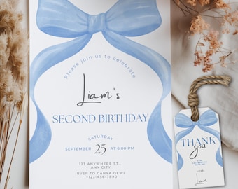 May include: A white rectangular birthday invitation card featuring a large watercolor-style light blue bow at the top, with text reading Liam's SECOND BIRTHDAY, Saturday September 25 at 6:00 PM, and a matching rectangular favor tag with twine.
