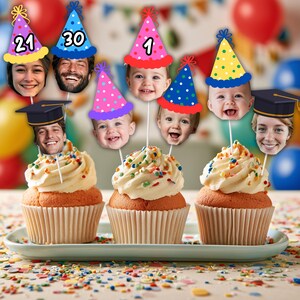 Pode incluir: Três cupcakes com cobertura branca e granulado colorido, cada um com recortes de rostos personalizados em palitos. Os rostos usam chapéus de festa azuis, rosas, amarelos ou capelos pretos. Alguns chapéus exibem os números 21, 30 ou 1.