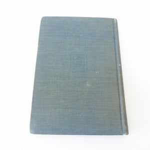May include: A blue hardcover book with a textured cover. The book has a title and author printed on the spine.