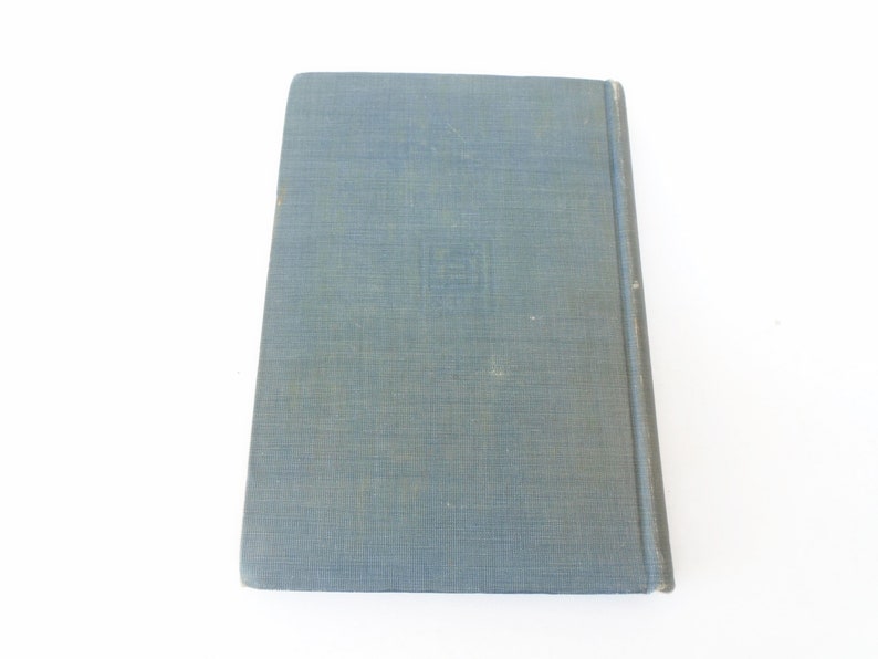 May include: A blue hardcover book with a textured cover. The book has a title and author printed on the spine.