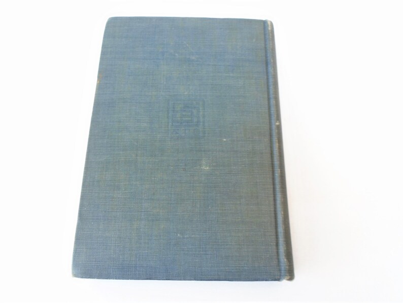 May include: A blue hardcover book with a textured cover. The book has a small, square design on the front cover.