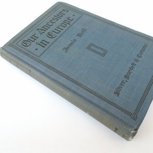 May include: A blue hardcover book titled "Our Ancestors in Europe" by Jennie Hall, published by Silver, Burdett & Company.