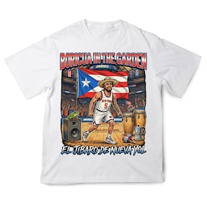 May include: A white t-shirt featuring a graphic of a basketball player wearing a straw hat, a jersey with the number 5, and shorts. The design includes a Puerto Rican flag, a frog on a speaker, conga drums, a coffee pot, and the text BORICUA IN THE GARDEN EL JIBARO DE NUEVA YOL.