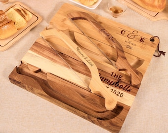 May include: Wooden bread boards and serving knives. The boards are made of light and dark wood, with a rectangular shape. The knives have curved handles and are engraved with names and dates. The boards are designed for serving bread and other foods.