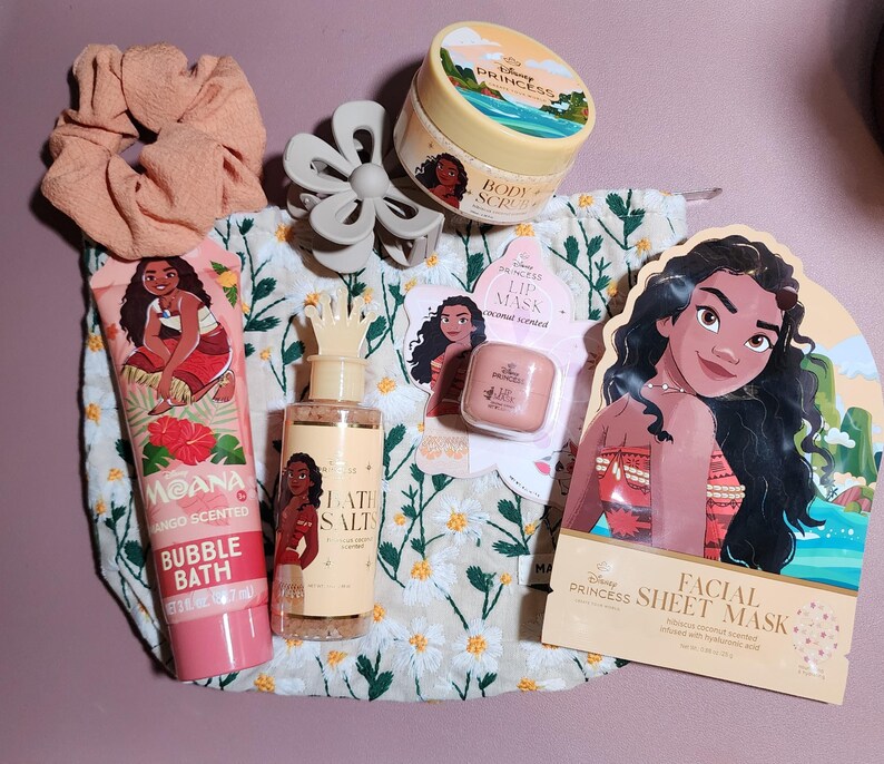 May include: A Disney Princess Moana themed beauty set including a floral print drawstring bag, a peach scrunchie, a grey hair claw, a mango scented bubble bath tube, bath salts, a coconut scented lip mask, a body scrub, and a facial sheet mask.