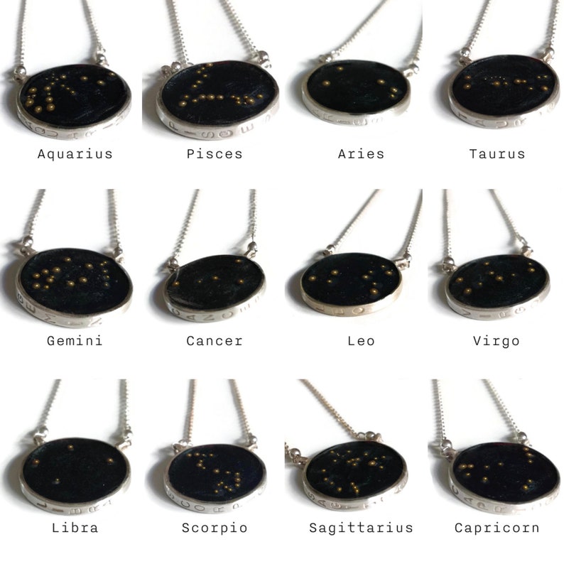 May include: Twelve silver necklaces with black circular pendants featuring gold star constellations representing the twelve zodiac signs: Aquarius, Pisces, Aries, Taurus, Gemini, Cancer, Leo, Virgo, Libra, Scorpio, Sagittarius, and Capricorn.