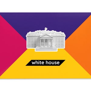 Product packaging for the White House paper model kit. The bright-colored cardstock envelope features an image of the finished model at the center and the product title below.