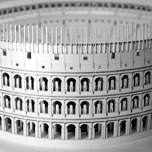 Assembled 3d scale model of the Roman Colosseum. The model of the ancient oval amphitheatre is made out of printed paper parts, the graphics feature external wall colonades and corridors and the inside with tiers of seats.