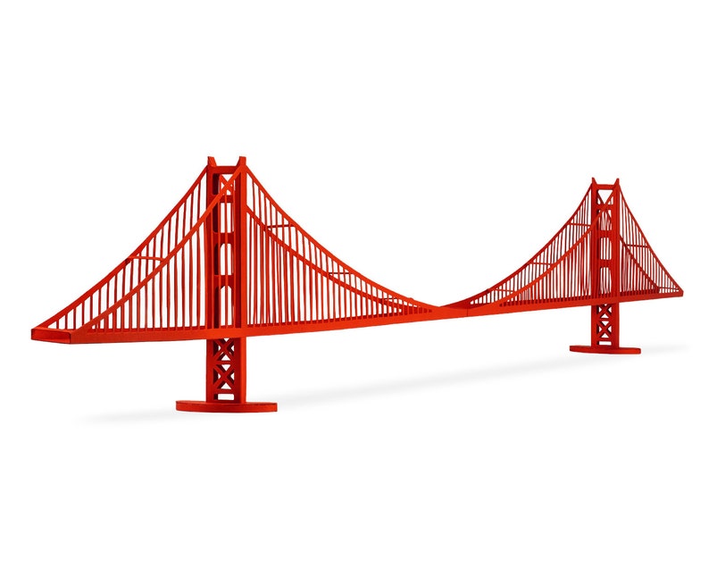 Diagonal view of the assembled 3d scale model of the Golden Gate bridge, made out of bright red die-cut cardstock parts. The model features two art-deco style bridge towers, a deck and cables.