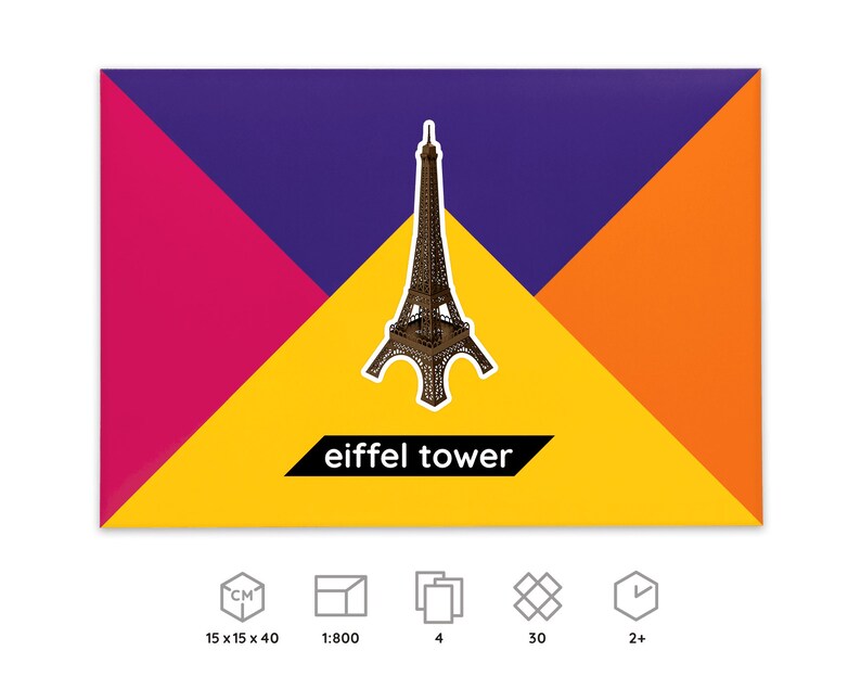 Packaging for PaperLandmarks' Eiffel Tower  paper model kit, icons below explain dimensions and scale of a finished model, number of worksheets included in the kit, parts to be cut out and assembled, time required for building the model.